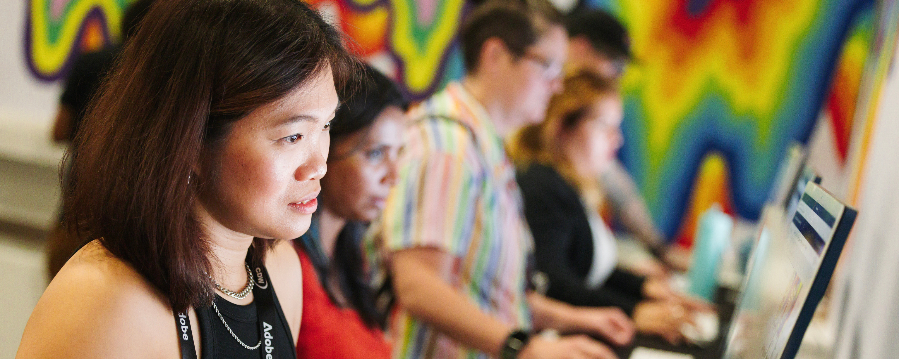 Attendees at Adobe MAX focus intently on creative projects during a hands-on session.